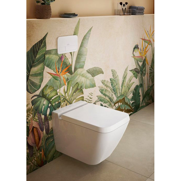 WC suspendu blanc marque Villeroy & Boch, design moderne, sur fond mural feuillage tropical