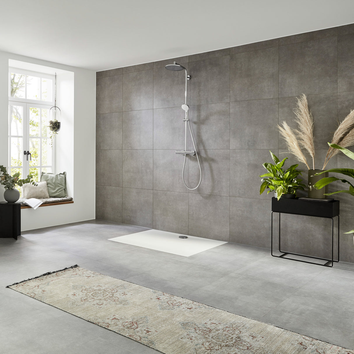 Colonne de douche Grohe, gris, installée dans une salle de bain moderne avec carrelage gris.