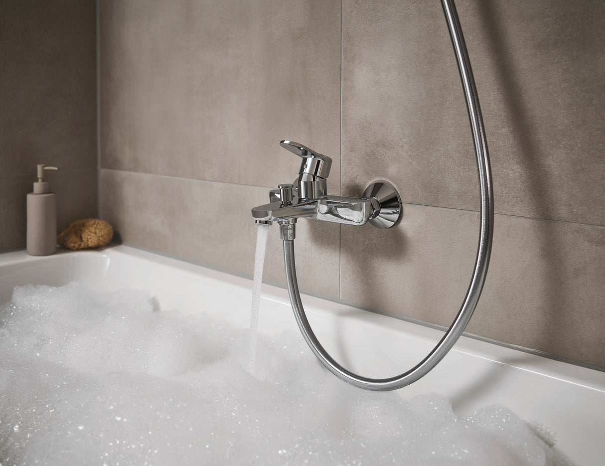 Mitigeur de baignoire Grohe, robinet chromé, couleur argent, installé sur carrelage beige.