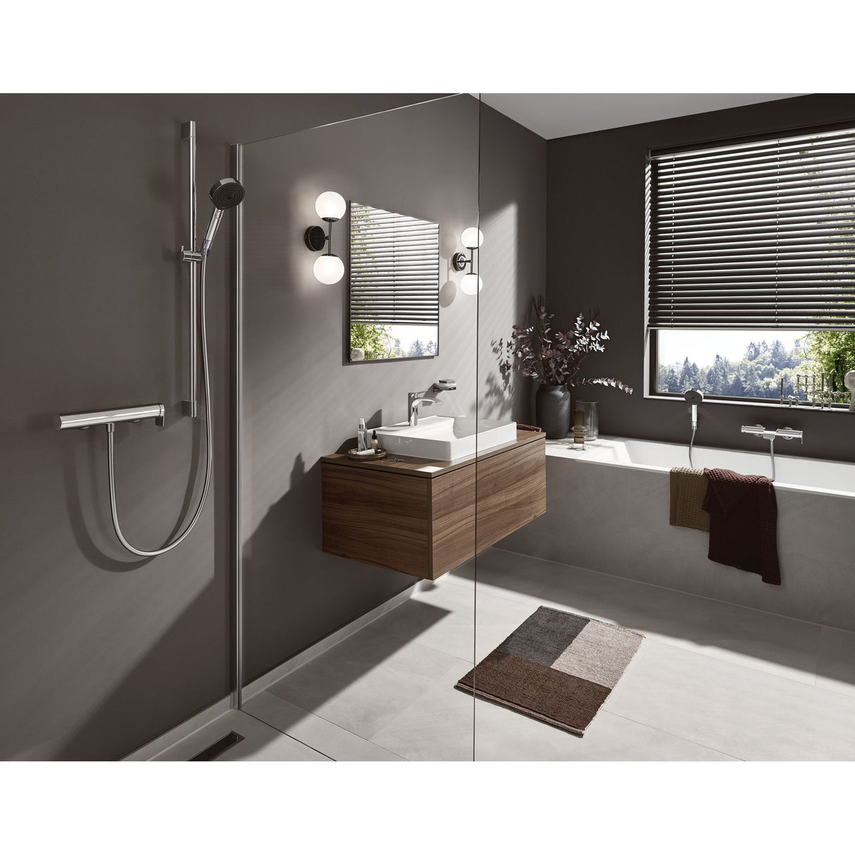 Salle de bain moderne avec robinetterie Grohe, douchette en inox argent, murs gris.