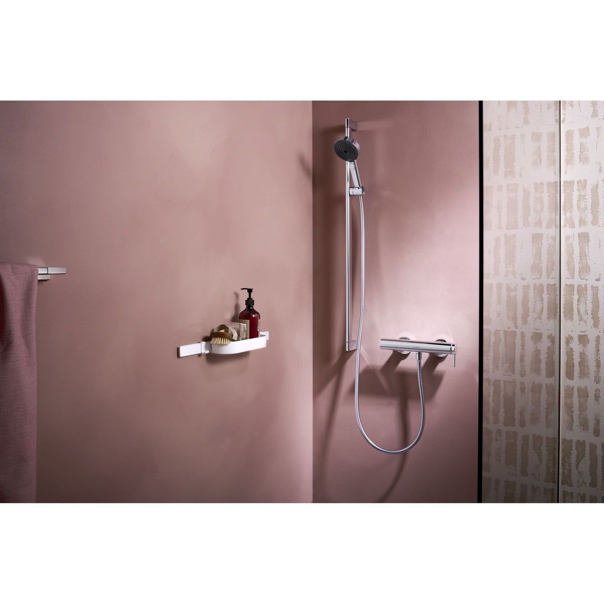 Douchette Grohe, colonne de douche, couleur chromée, sur mur rose dans salle de bain