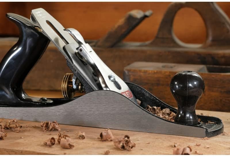 Rabot à main Stanley, outil de menuiserie, couleur noire et métallique, sur établi en bois.