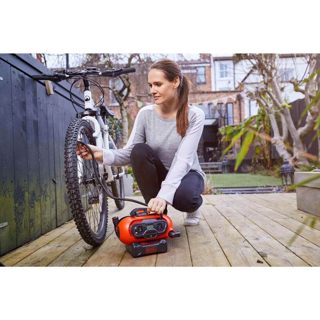 Compresseur Black+Decker portable orange pour pneus de vélo, utilisé en extérieur