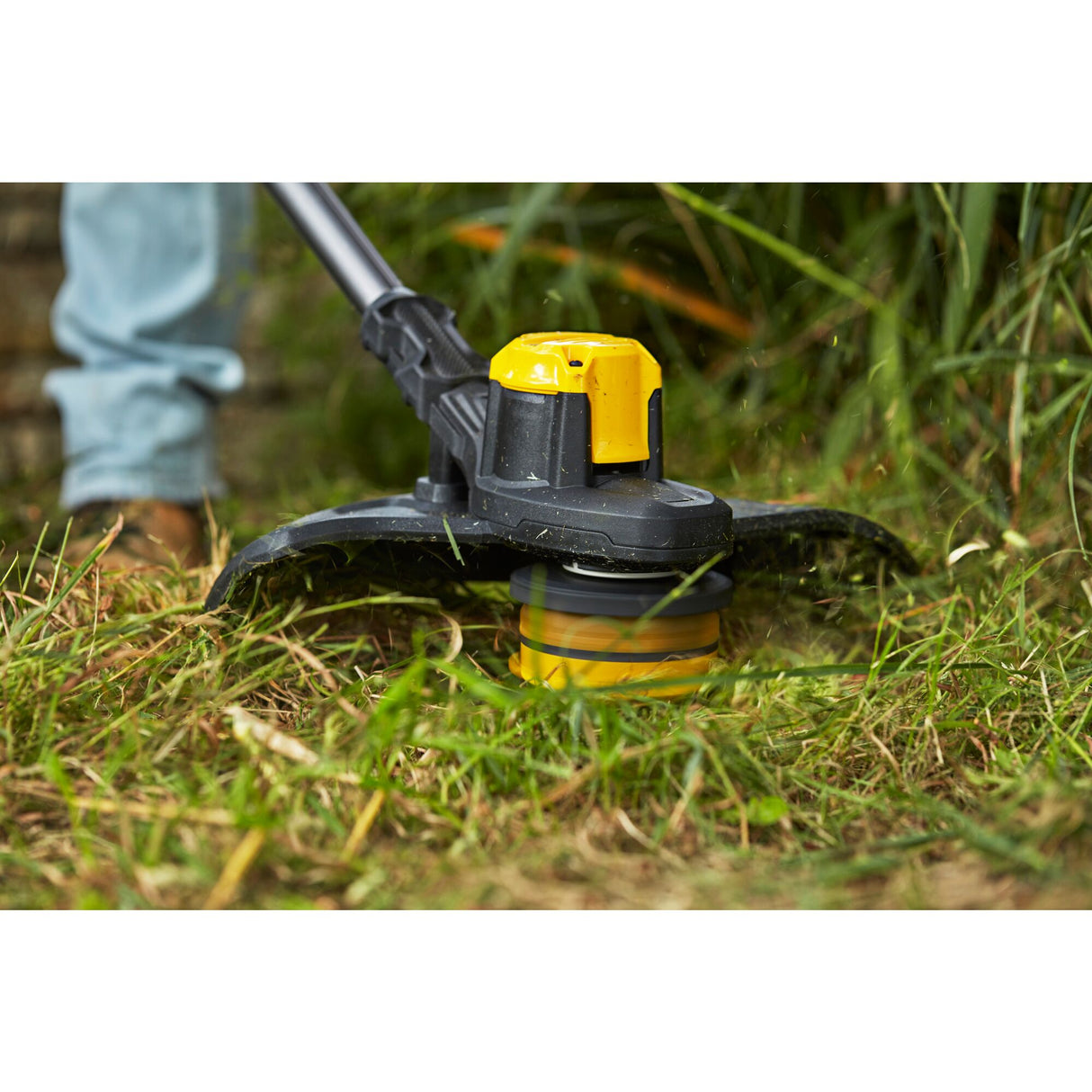 Coupe-bordures Stanley, outil de jardinage, noir et jaune, en action sur l'herbe