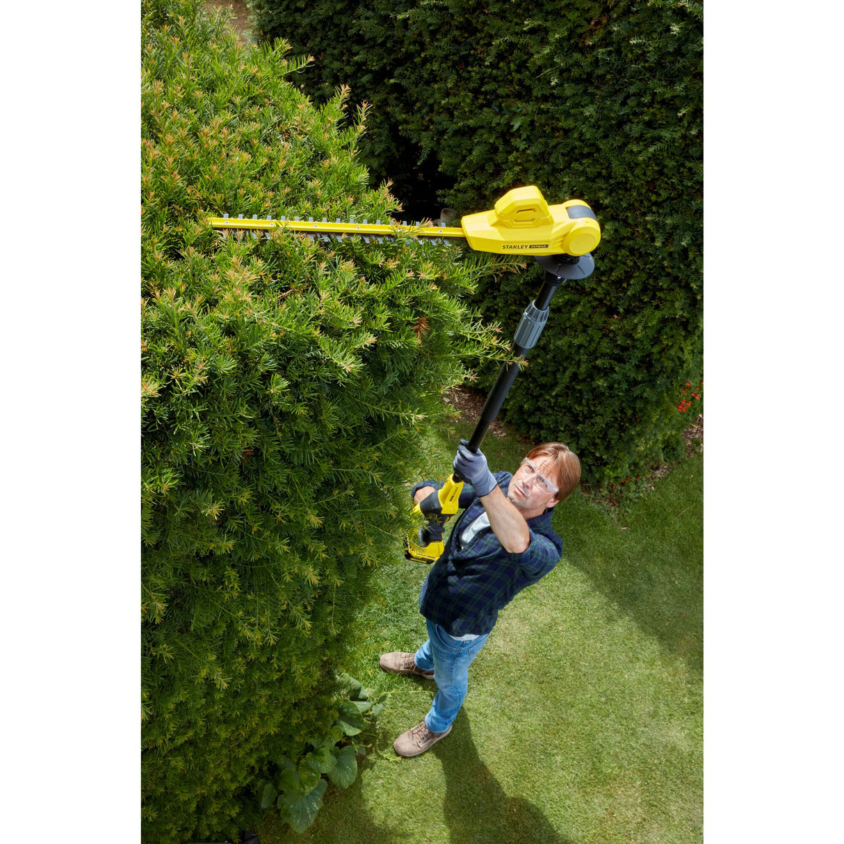 Taille-haie télescopique Stanley, outil électrique jaune, utilisé pour tailler une haie