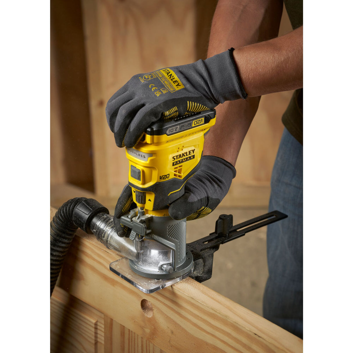 Défonceuse jaune Stanley en action sur bois, outil électroportatif de couleur jaune
