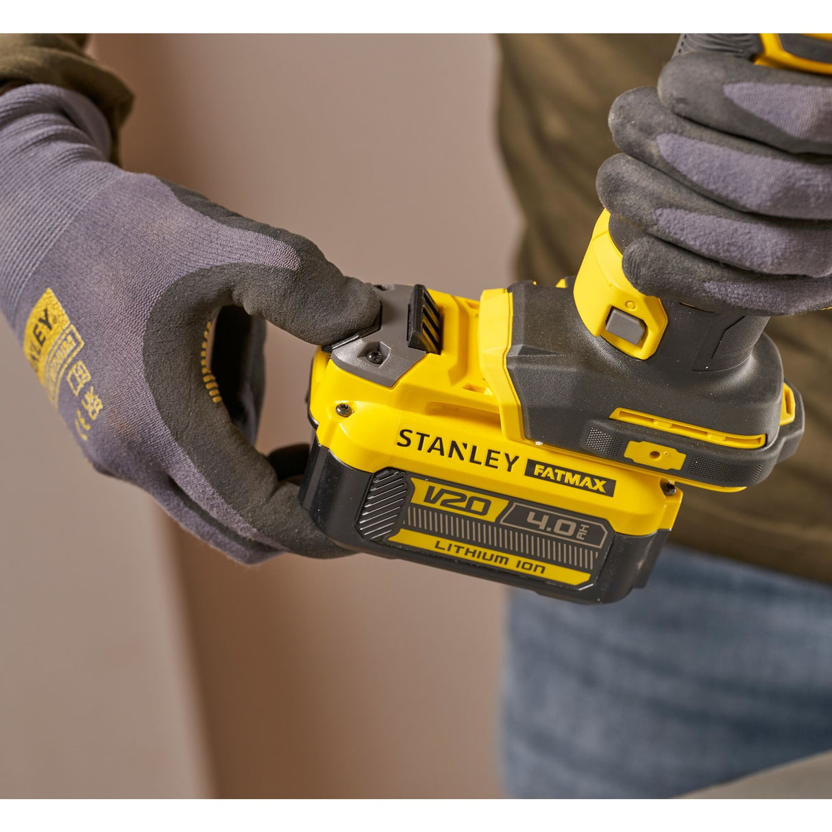 Perceuse-visseuse Stanley Fatmax V20 jaune et noire, tenue par une main gantée
