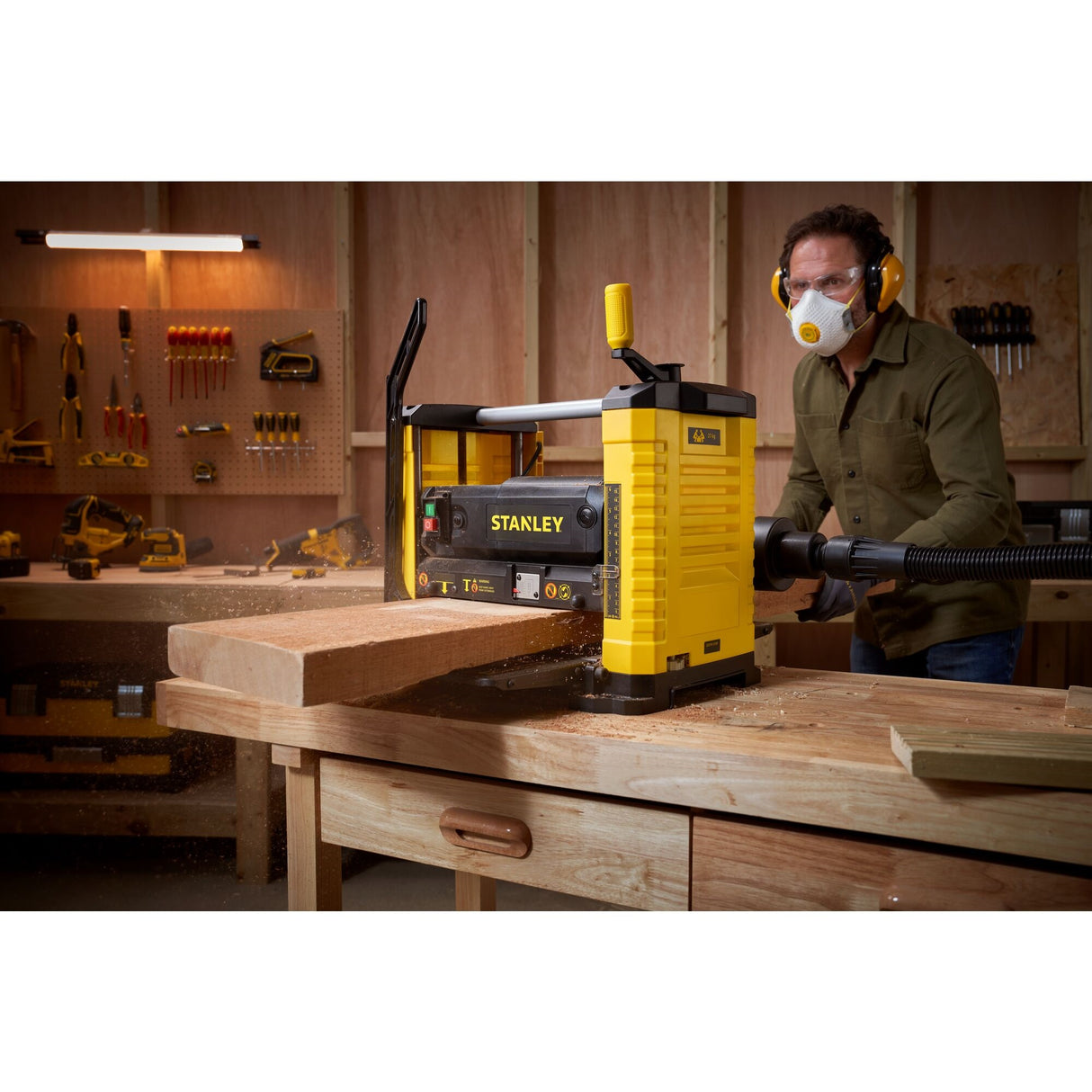 Raboteuse Stanley jaune pour bois, outil électroportatif, en atelier de menuiserie.