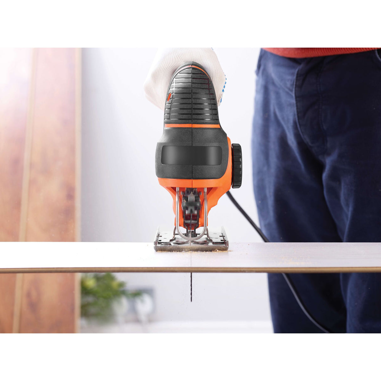 Scie sauteuse Black+Decker, outil électroportatif orange et noir en action sur bois.
