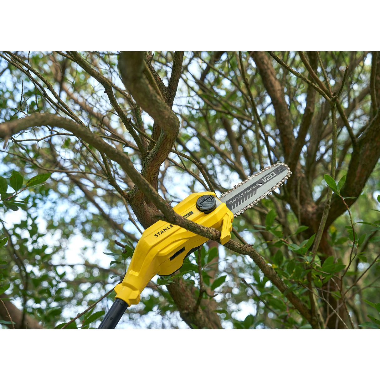 Élagueuse Stanley, outil de jardinage jaune, taille une branche d'arbre.
