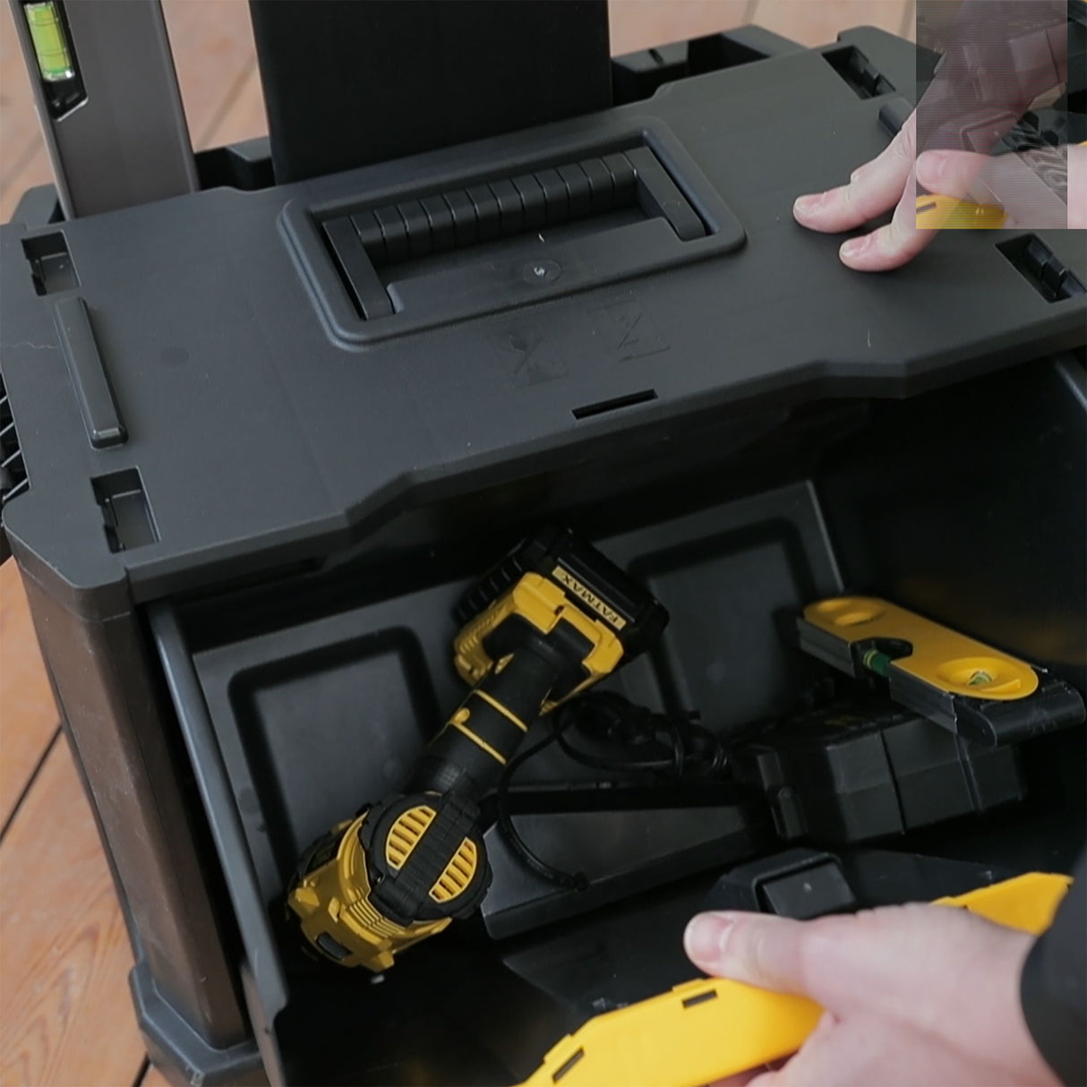 Boîte à outils noire Stanley avec perceuse jaune et niveau à bulle, outils de marque Stanley.
