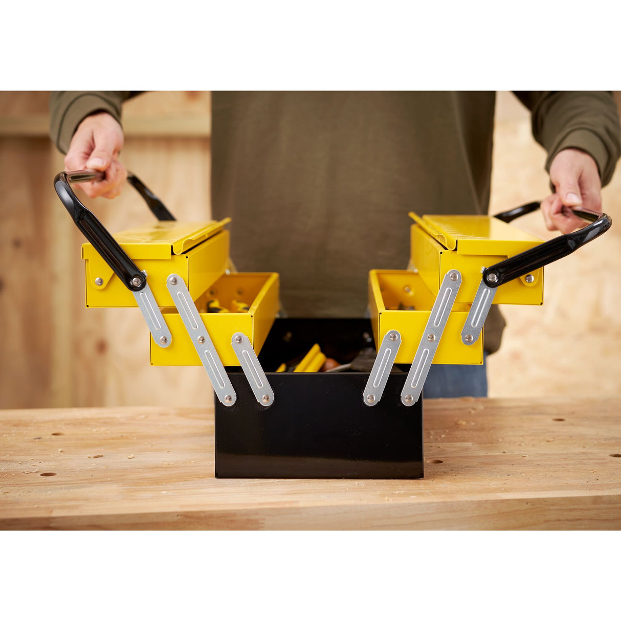 Boîte à outils Stanley, métallique, couleur jaune et noire, ouverte sur un établi