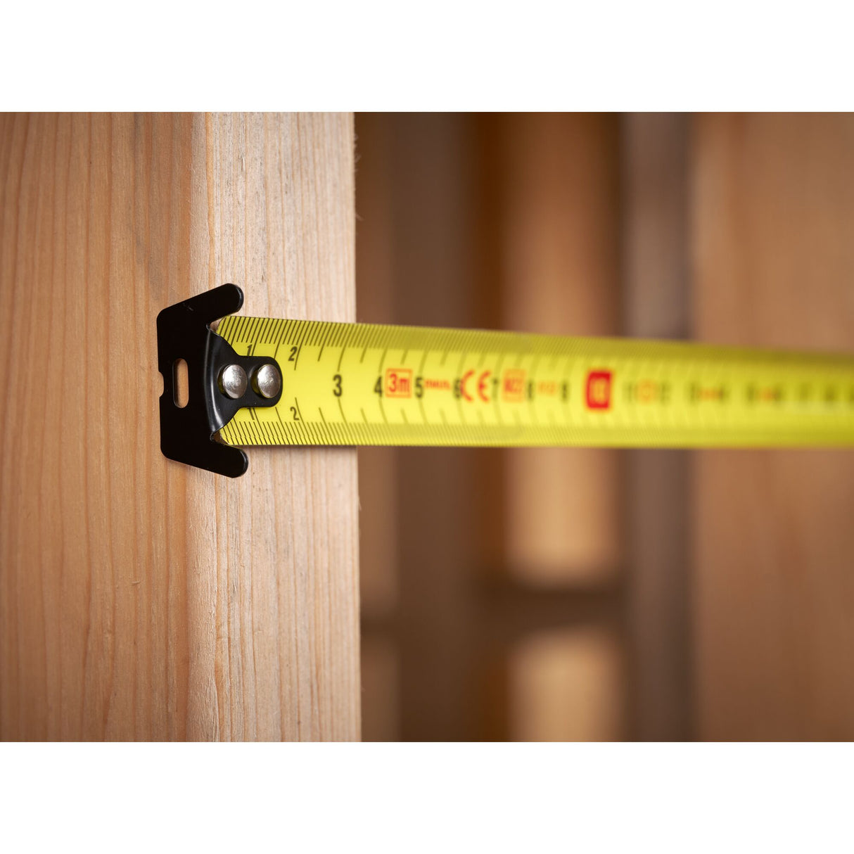 Mètre ruban Stanley jaune pour mesure, outil de bricolage, sur une poutre en bois