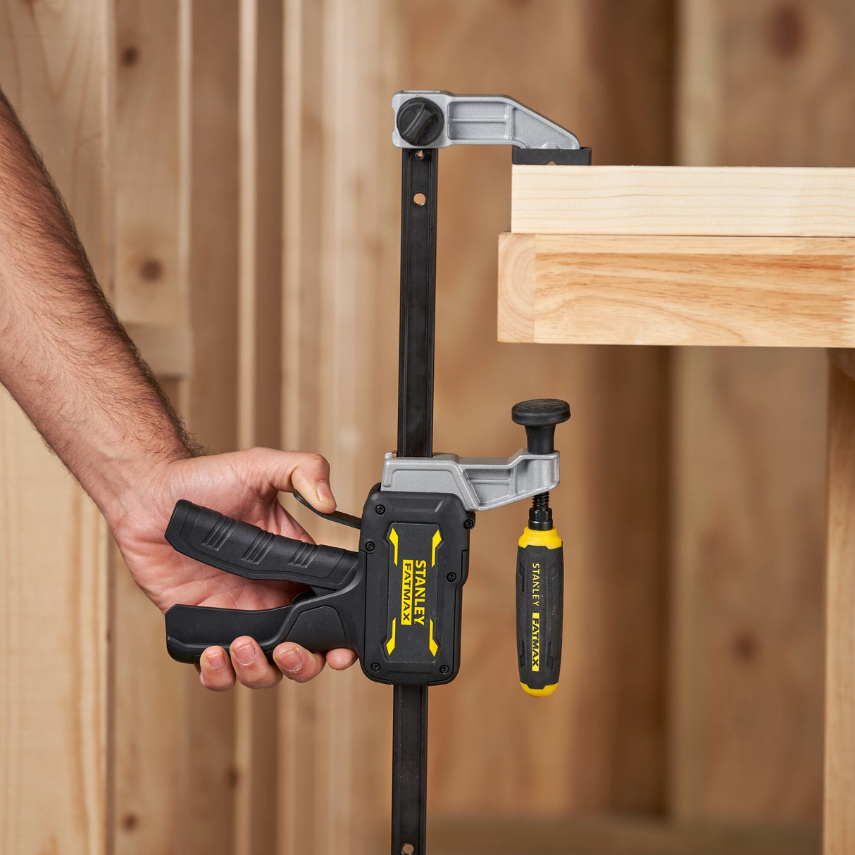 Serrage à main Stanley Fatmax noir et jaune fixé sur un établi, serre-joint de menuiserie.