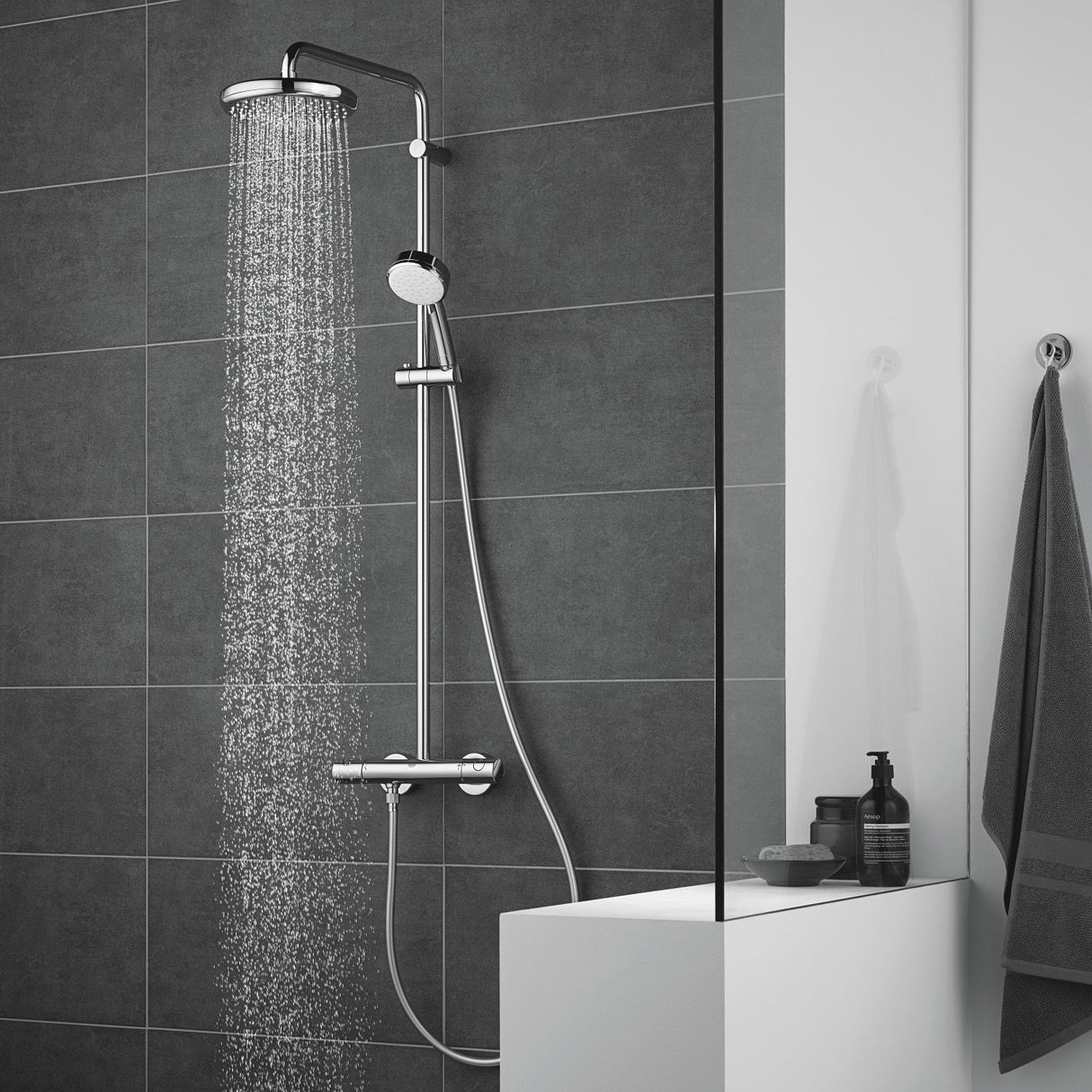 Douche Grohe, colonne de douche chromée, couleur argent, moderne sur carrelage gris.