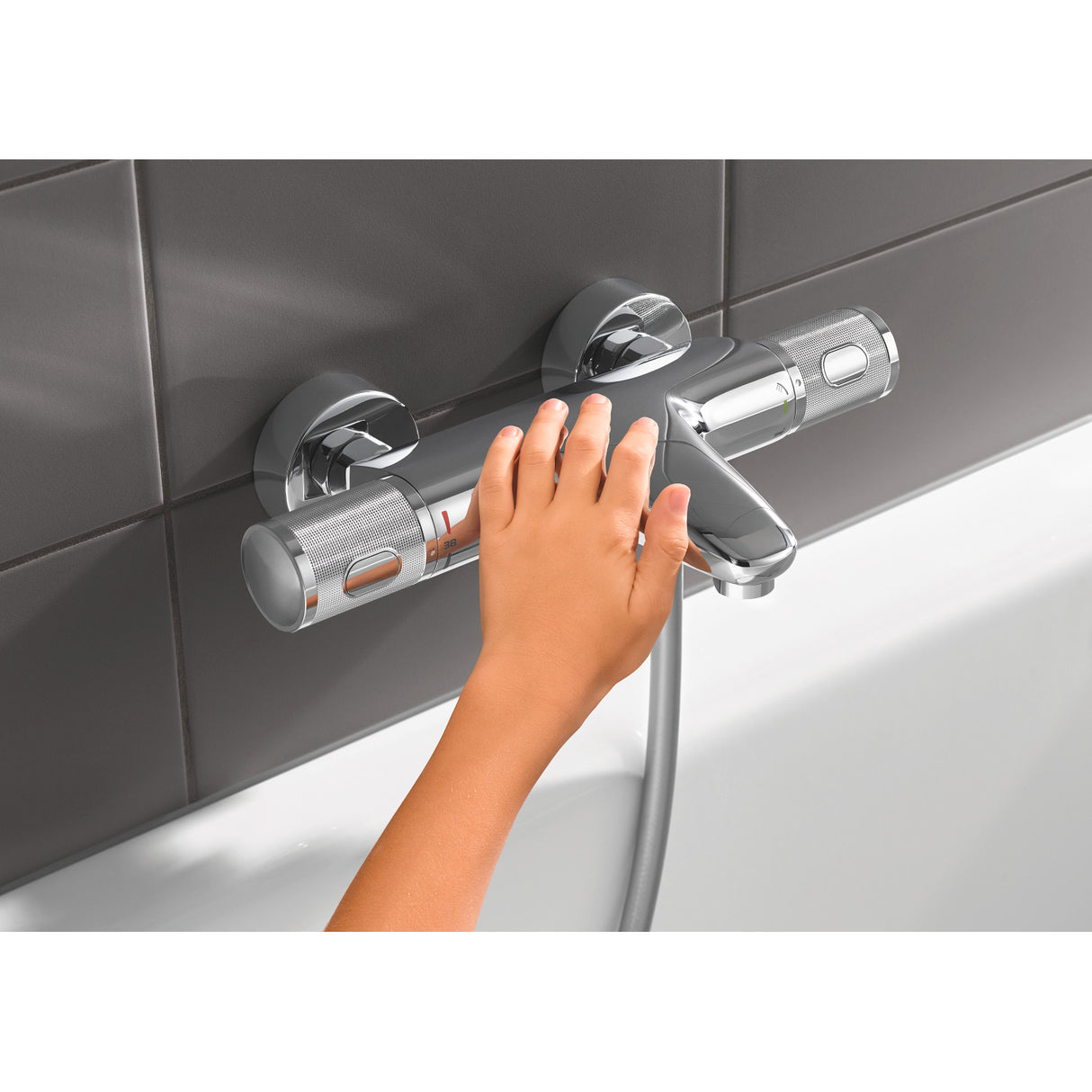 Mitigeur de baignoire Grohe chromé, main réglant le robinet, couleur argentée