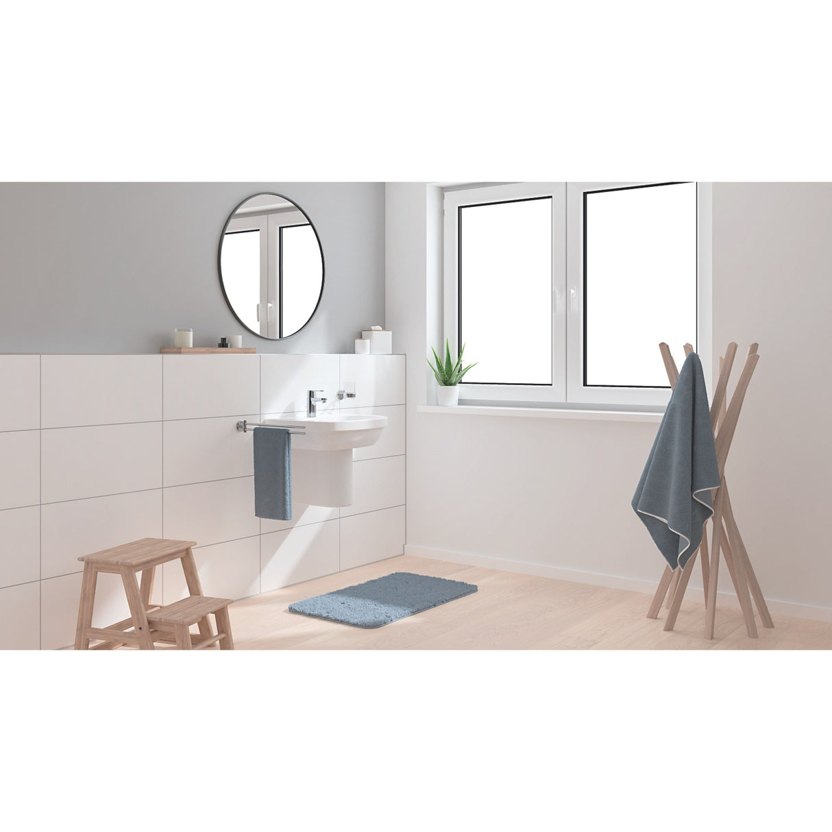 Tapis de bain bleu Grohe pour salle de bain moderne, posé devant un lavabo blanc.