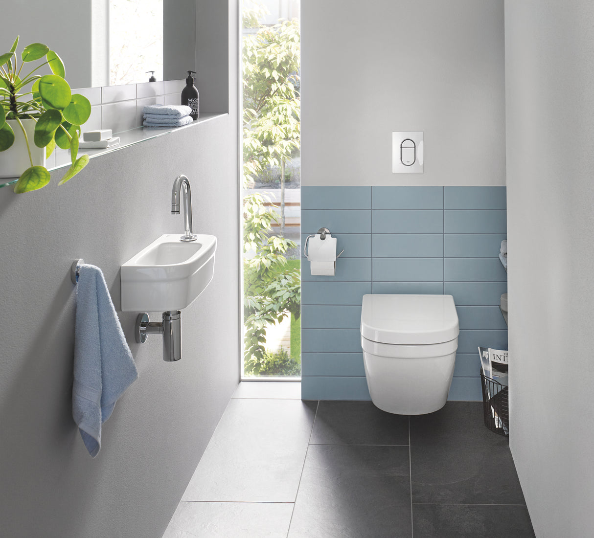 Toilette suspendue blanche Grohe, design moderne, avec carrelage bleu dans une salle de bain