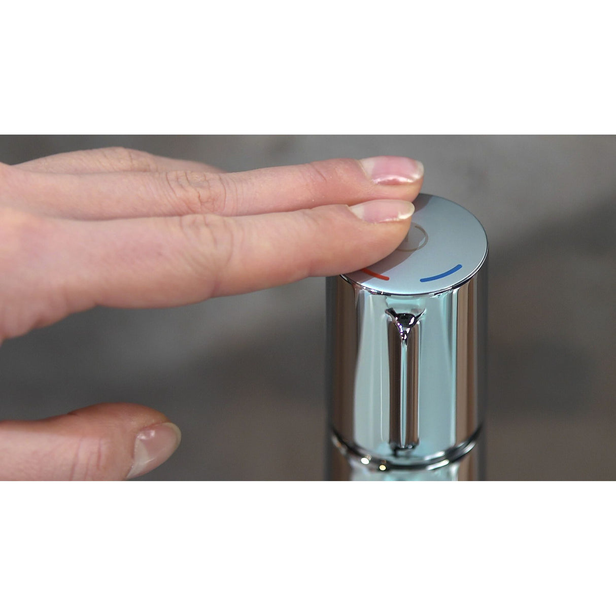 Mitigeur Grohe chromé, robinet salle de bain couleur argent, main appuyant sur le dessus