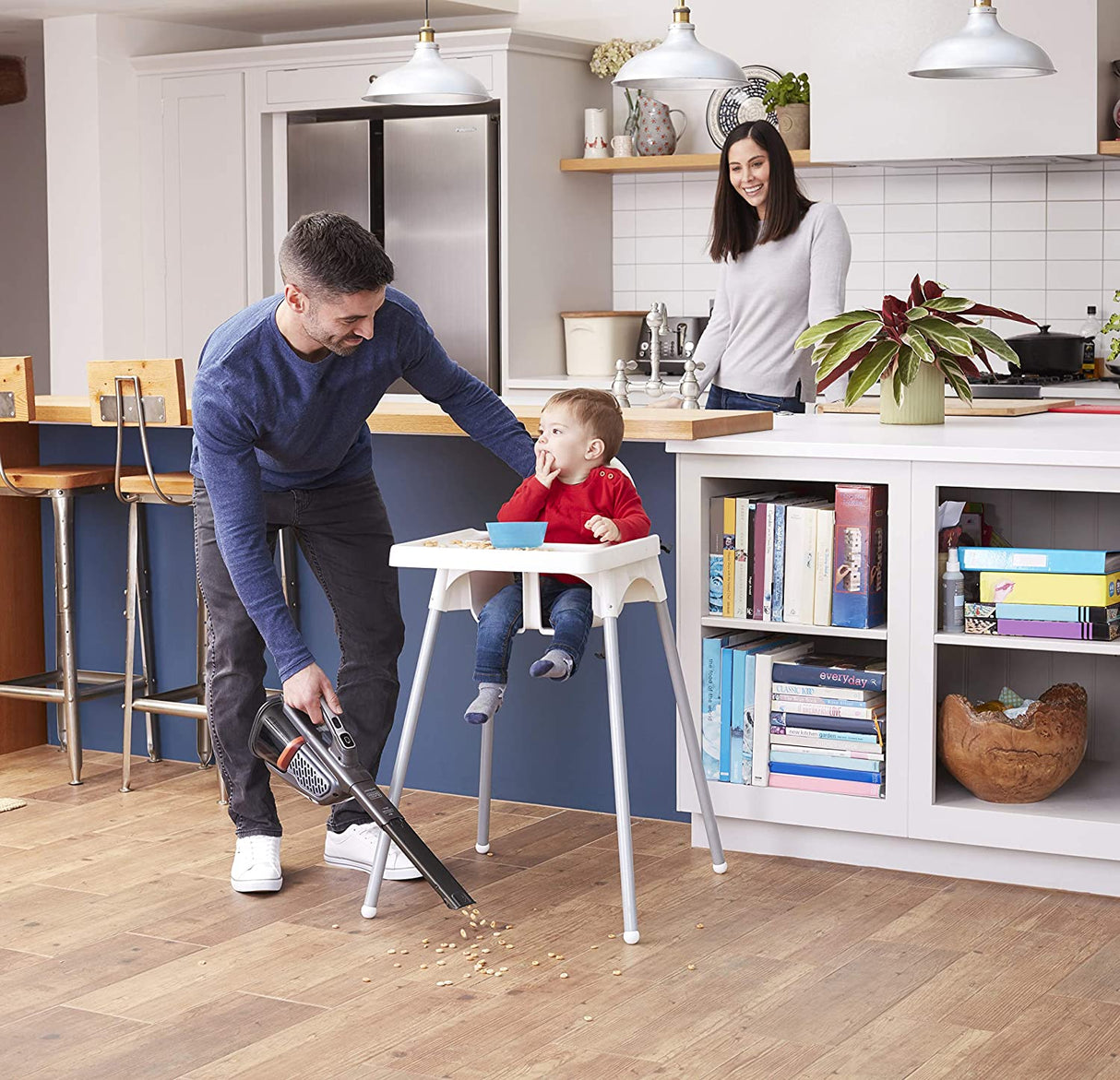 Aspirateur à main Black+Decker, sans fil, noir et orange, utilisé dans une cuisine moderne