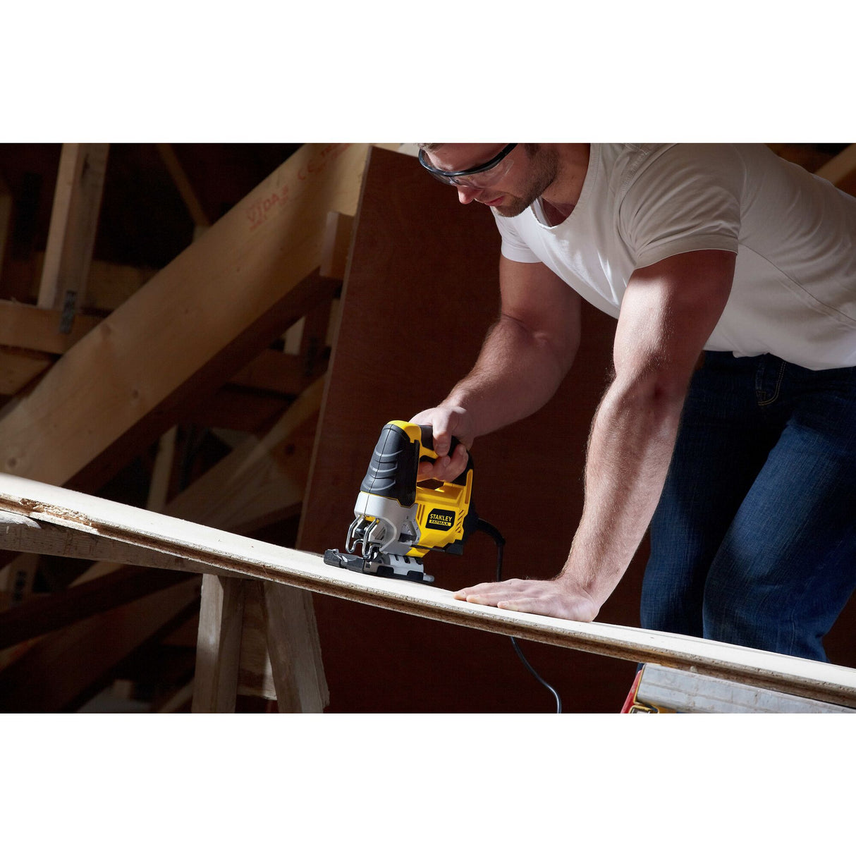Scie sauteuse électrique Stanley, outil électroportatif, jaune et noire, en action sur bois