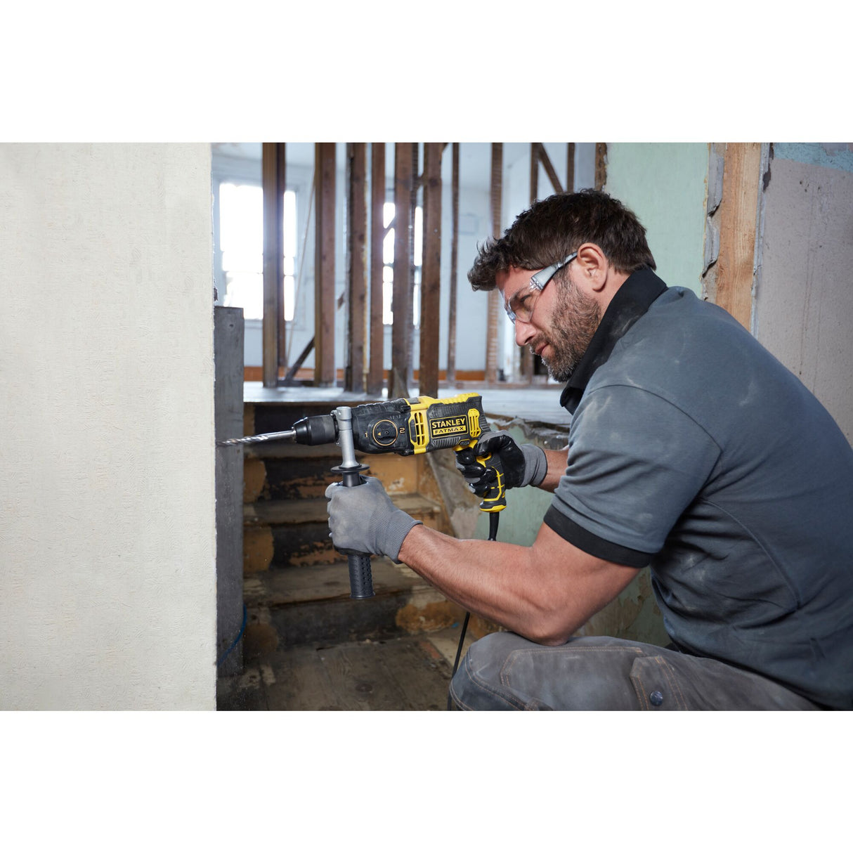 Perforateur Stanley, outil électroportatif jaune et noir, utilisé par un homme en chantier