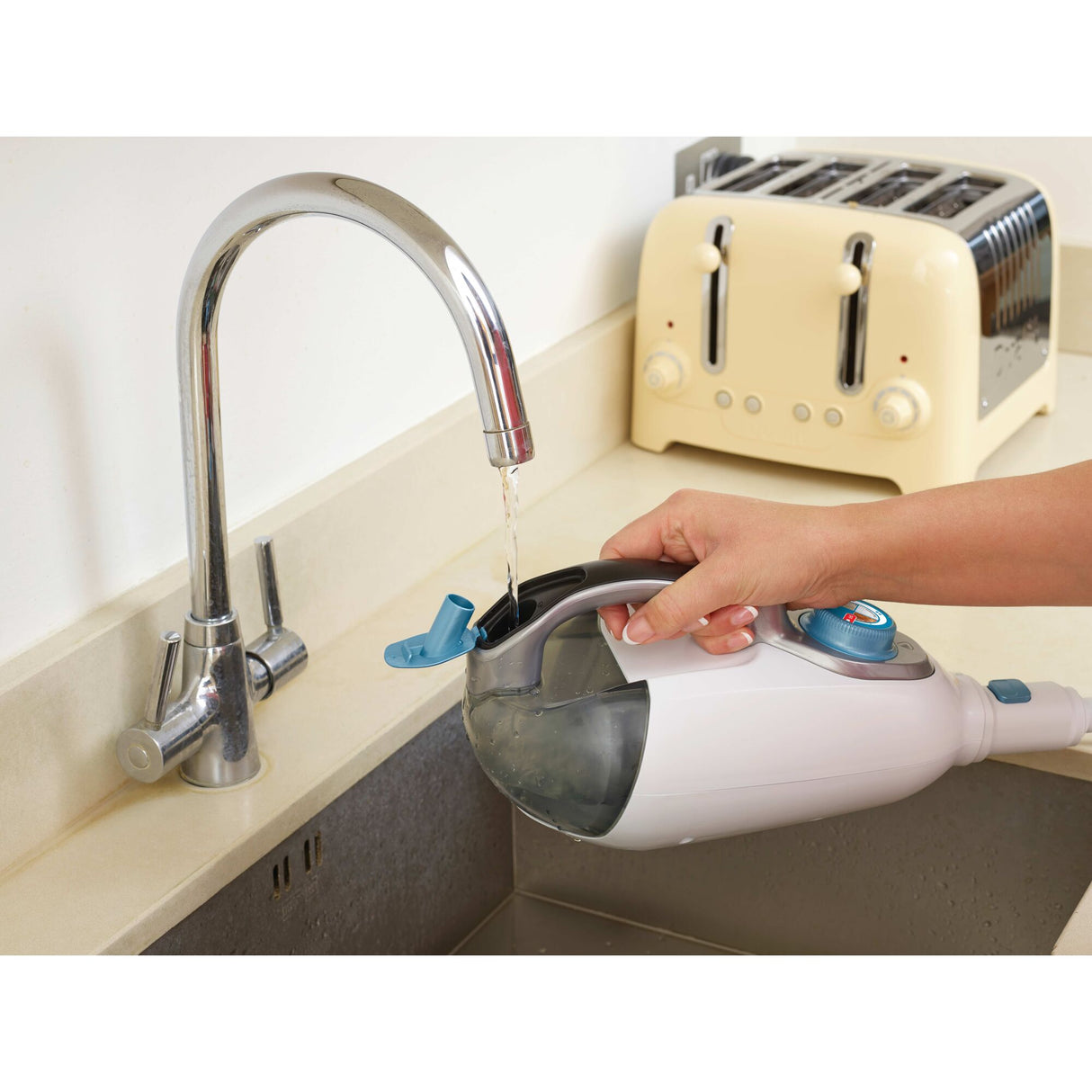 Réservoir transparent de nettoyeur vapeur Morphy Richards, blanc et bleu, rempli au robinet.