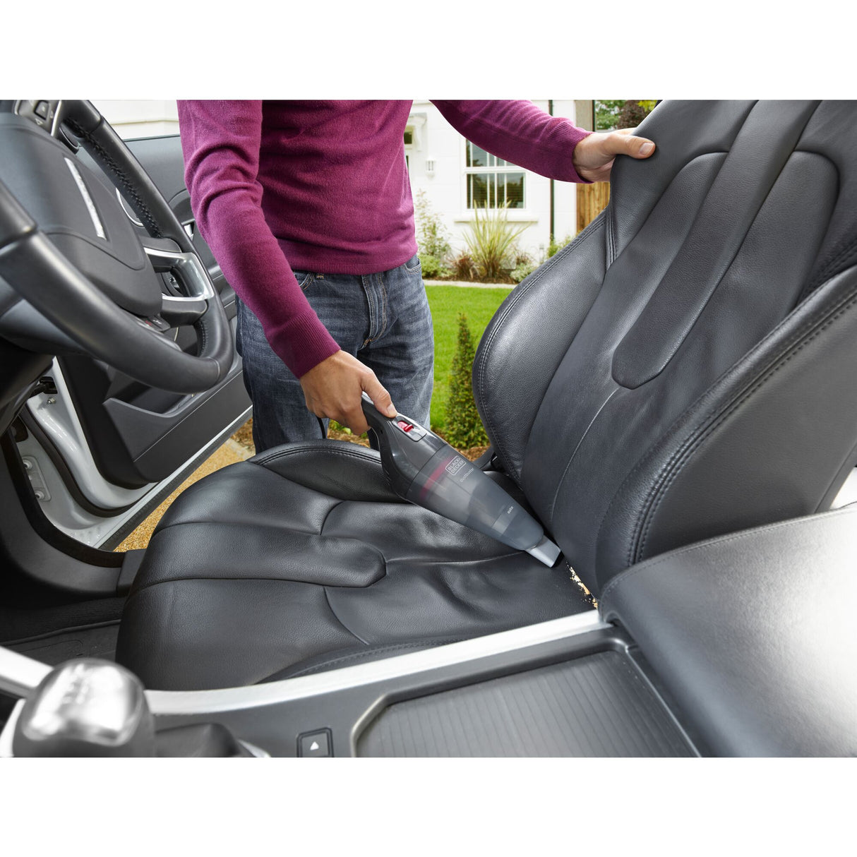 Aspirateur à main Black+Decker, noir, utilisé pour nettoyer un siège auto en cuir