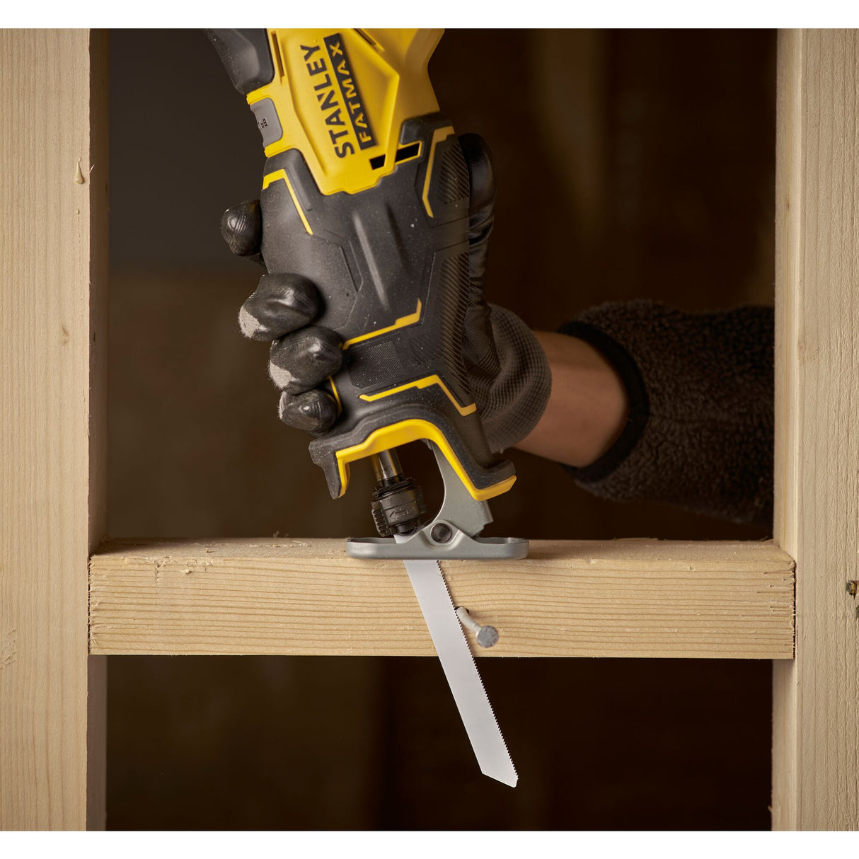 Scie sabre Stanley FATMAX jaune et noire en action, coupe de bois, outil électroportatif.