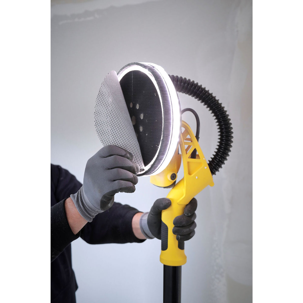 Ponceuse murale jaune de la marque Mirka, type électrique, en utilisation