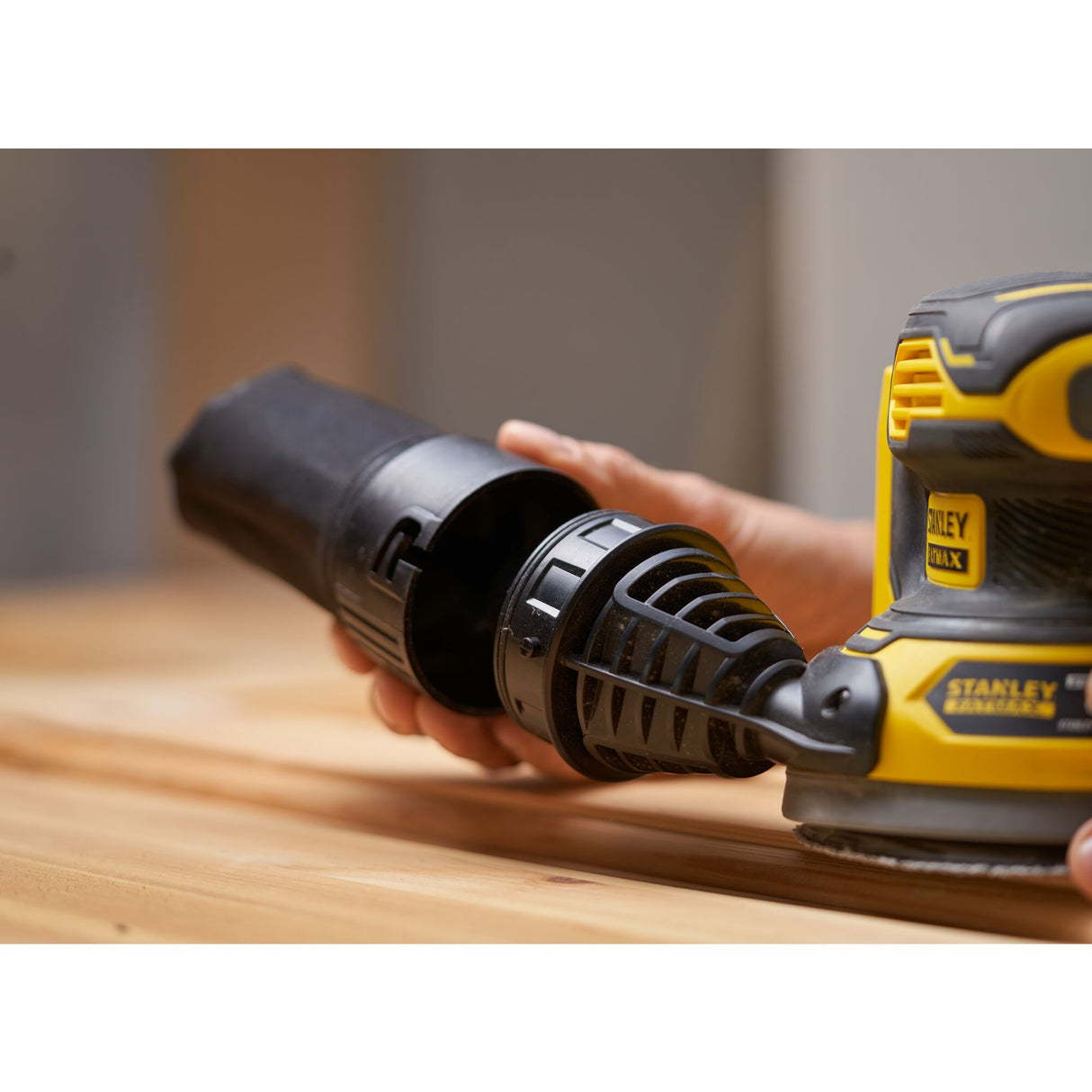 Ponceuse électrique Stanley, couleur jaune et noire, en cours d'utilisation sur bois