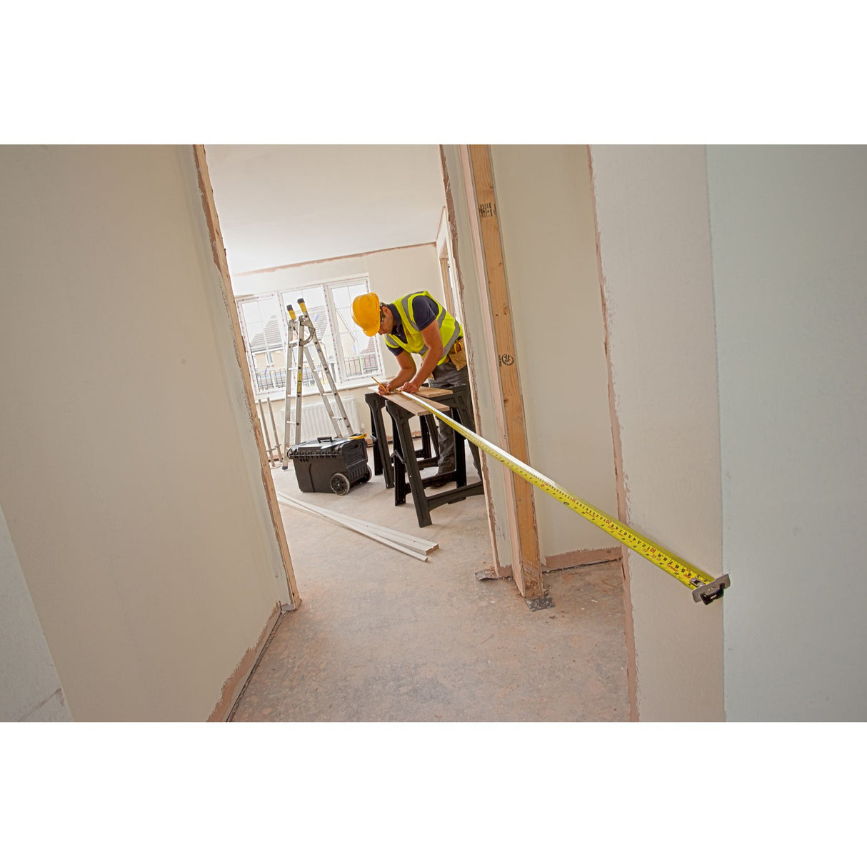 Stanley mètre ruban, outil de mesure jaune, utilisé sur chantier de rénovation intérieure.