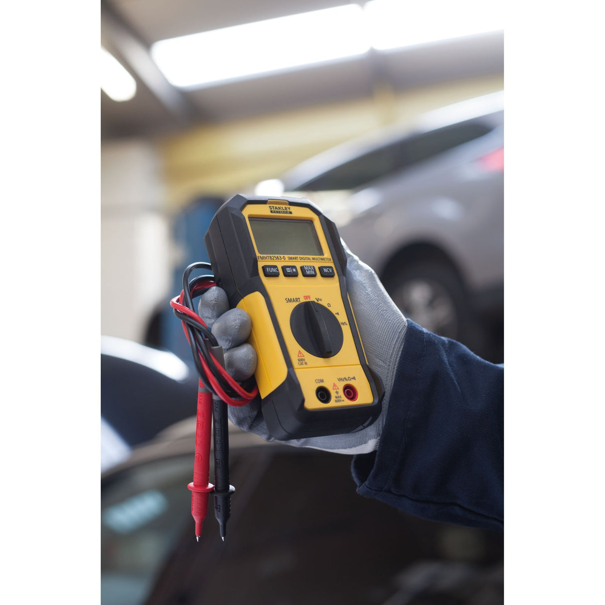 Multimètre jaune et noir Stanley, appareil de mesure électronique, tenu à la main