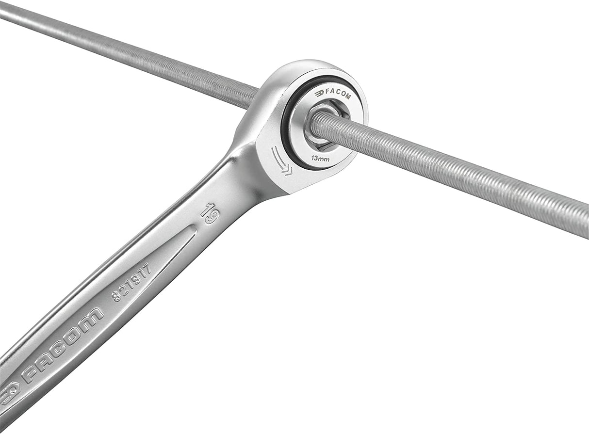 Clé à cliquet Facom, outil argenté, utilisée sur une tige filetée, couleur argent.