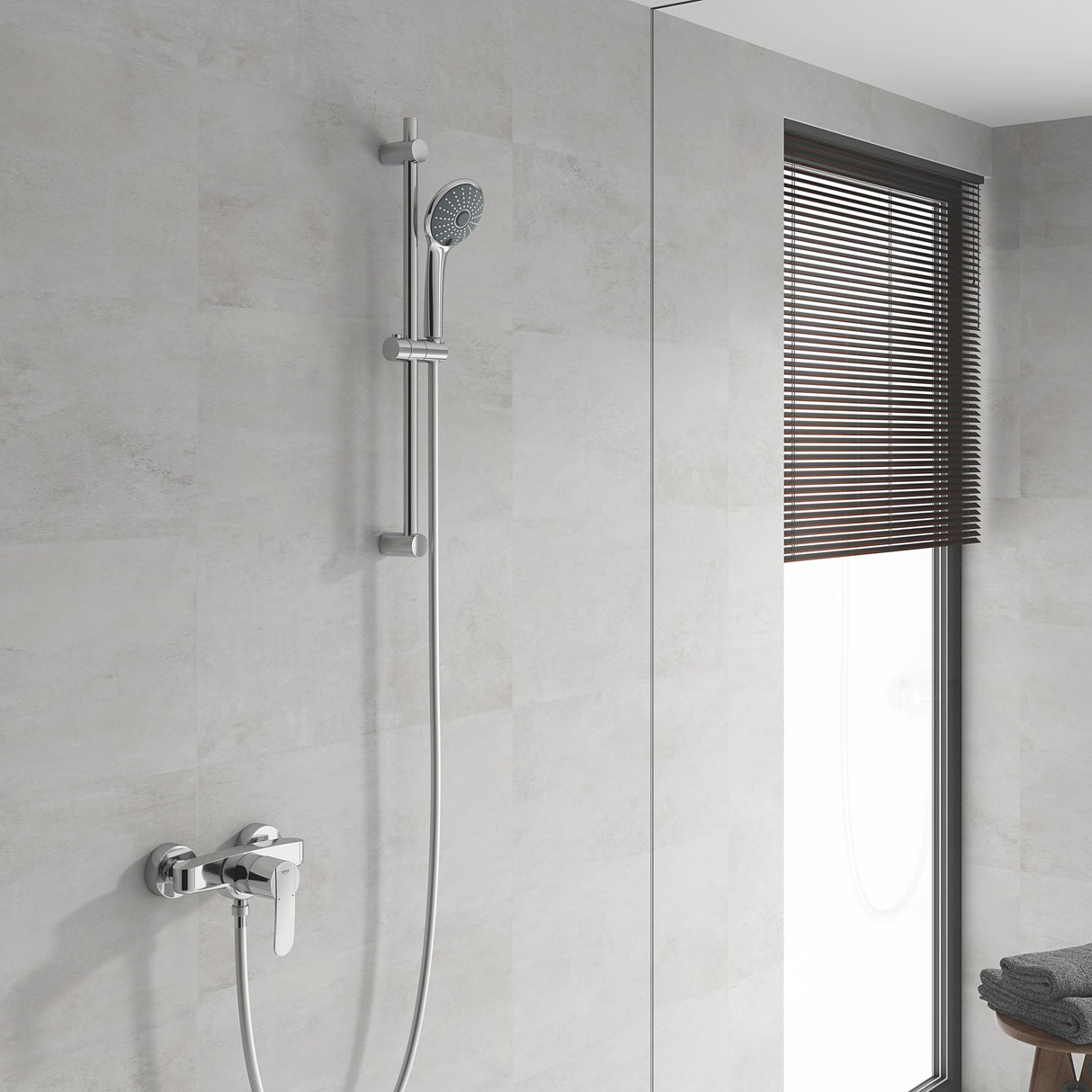 Colonne de douche Grohe chromée, robinetterie moderne, couleur argent, installée sur carrelage clair