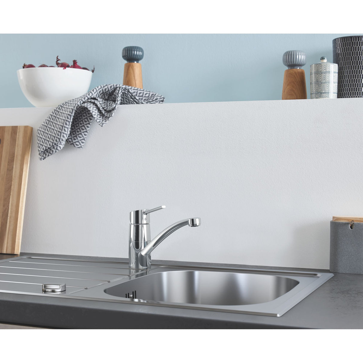 Mitigeur de cuisine Grohe chromé, robinet mélangeur brillant sur évier inox, couleur argenté.