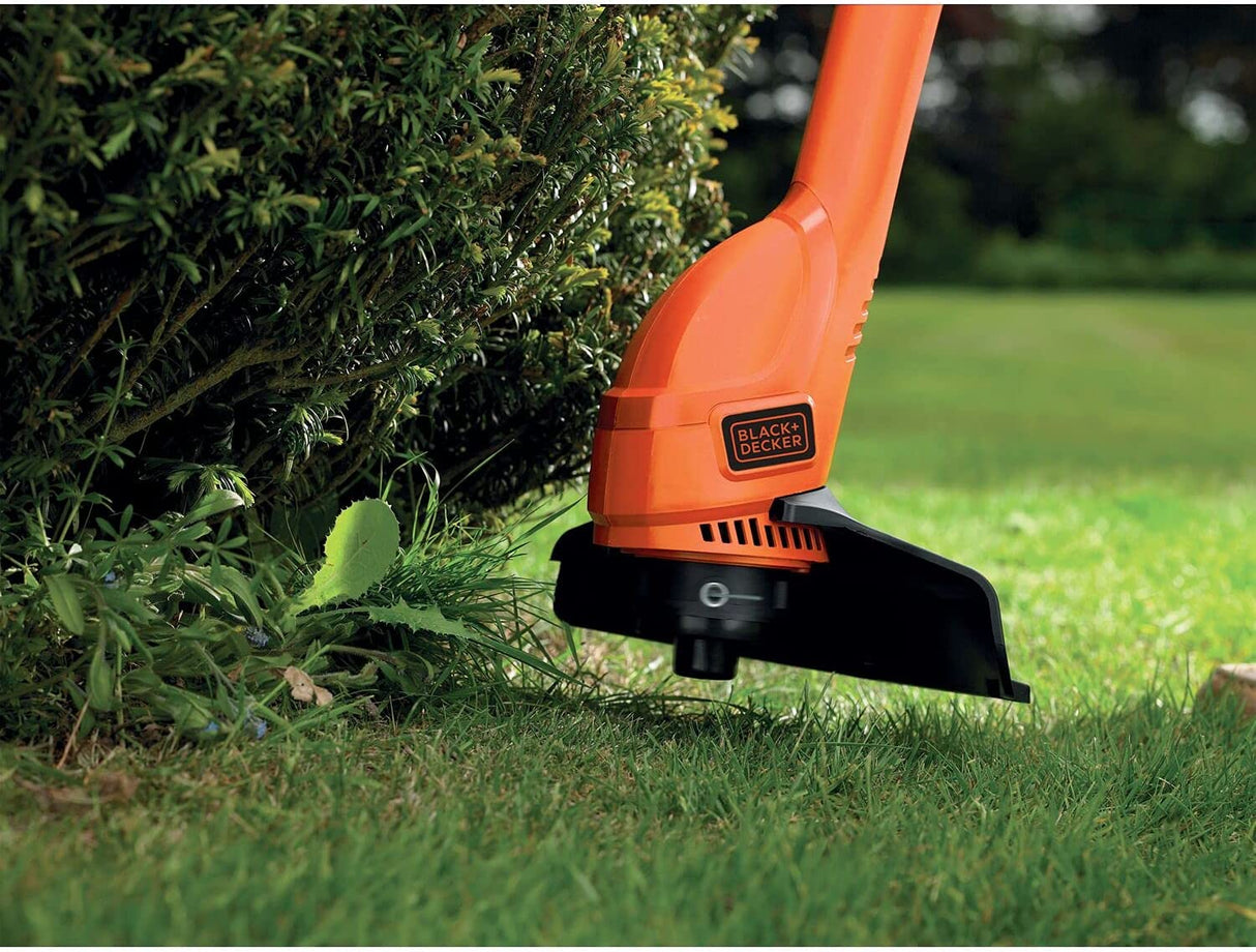 Coupe-bordures BLACK+DECKER, outil de jardinage orange, usage sur pelouse.