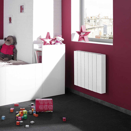 Radiateur blanc Atlantic électrique mural dans une chambre d'enfant avec murs bordeaux