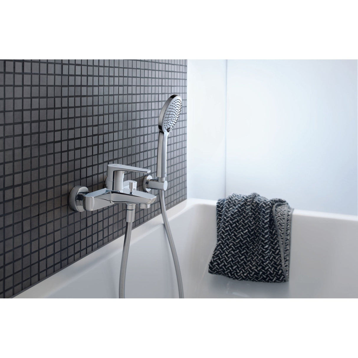 Mitigeur bain-douche Grohe, chromé, installé sur mur carrelé avec pommeau de douche.