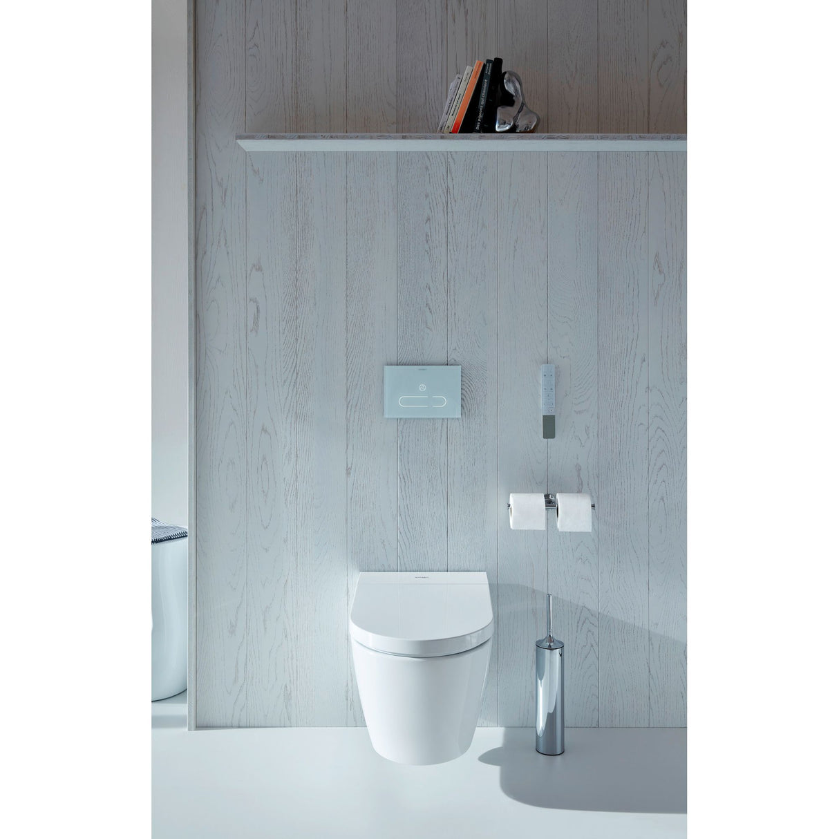 Toilette suspendue Grohe blanche, design moderne, avec télécommande murale et accessoires chromés.