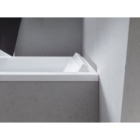 Baignoire blanche Grohe avec appuie-tête intégré, design moderne, installée dans une salle de bain grise.