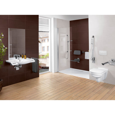 Salle de bains accessible Grohe, WC suspendu blanc, cabine de douche avec siège gris et barres d'appui.