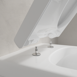Abattant WC blanc, marque Grohe, type sanitaire, avec charnières métalliques chromées.