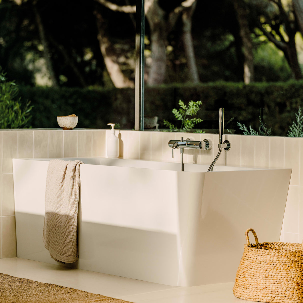 Baignoire blanche Grohe, type îlot, dans salle de bain moderne, lumière naturelle.