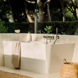 Baignoire blanche Grohe, type îlot, dans salle de bain moderne, lumière naturelle.