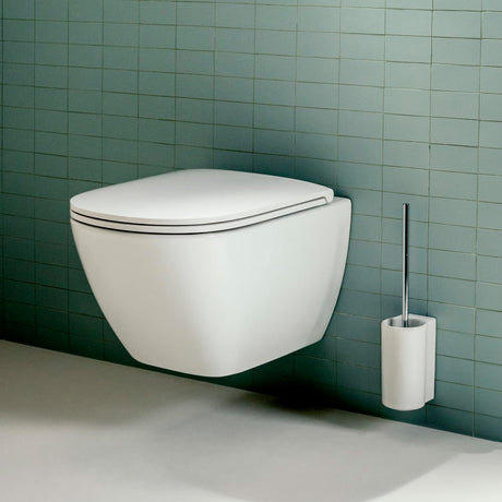 WC suspendu Grohe blanc avec porte-brosse mural, sanitaire moderne contre carrelage vert