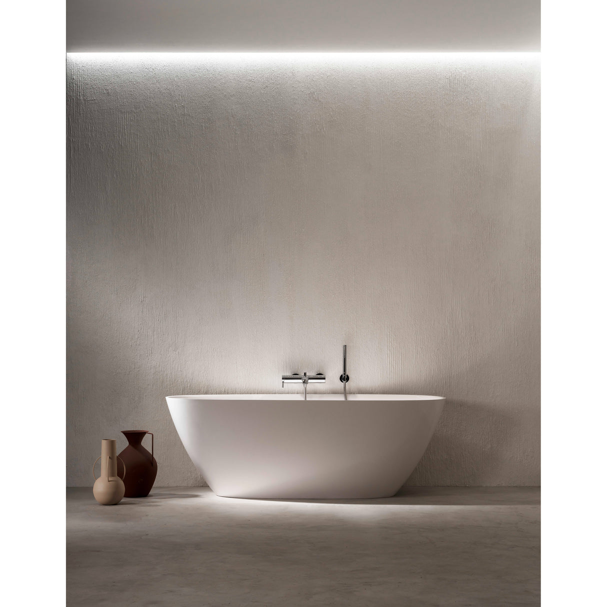 Baignoire blanche Falper, type îlot, couleur blanc, design moderne devant mur clair.