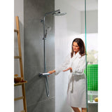 Femme utilisant une colonne de douche Grohe, finition chromée, dans une salle de bain moderne.