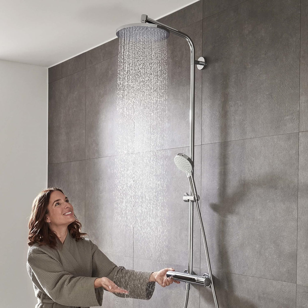 Colonne de douche Grohe chromée avec pommeau rond, installée sur carrelage gris