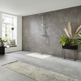 Colonne de douche Grohe, gris, installée dans une salle de bain moderne avec carrelage gris.